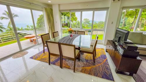 a dining room with a glass table and a couch at Caliraya Heights Resorts and Events Place in Halang