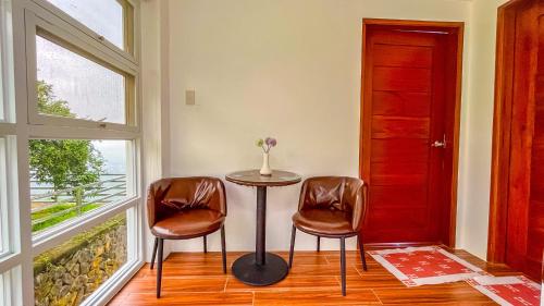 a table and two chairs in a room with a window at Caliraya Heights Resorts and Events Place in Halang