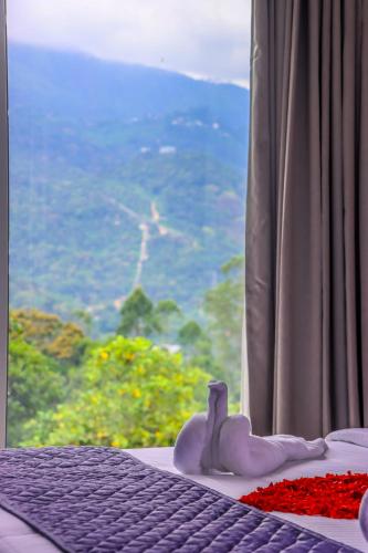 a bedroom with a bed and a window with a view at Winter Note Resorts in Munnar