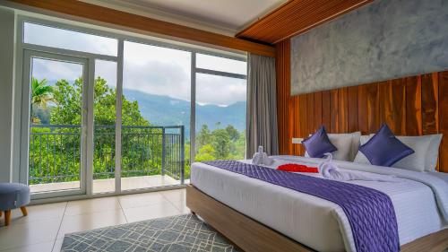 een slaapkamer met een groot bed en een groot raam bij Winter Note Resorts in Munnar