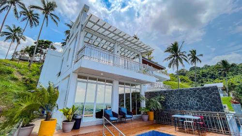 a house with a balcony with a view of the ocean at Caliraya Heights Resorts and Events Place in Halang