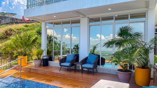 a porch with blue chairs and a view of the ocean at Caliraya Heights Resorts and Events Place in Halang