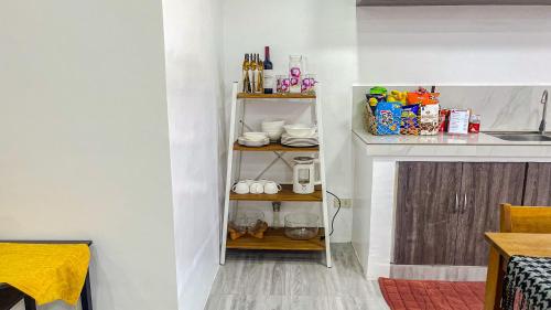 a kitchen with a shelf with cups and dishes at Caliraya Heights Resorts and Events Place in Halang