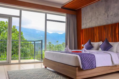 a bedroom with a large bed and large windows at Winter Note Resorts in Munnar
