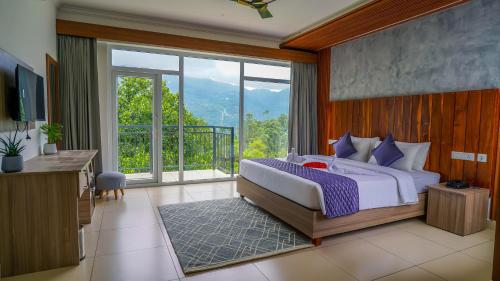 a bedroom with a large bed and a large window at Winter Note Resorts in Munnar
