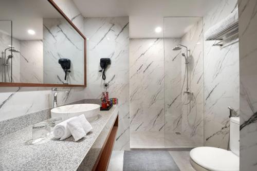 a bathroom with a sink and a shower at The Alana Hotel Malang in Malang