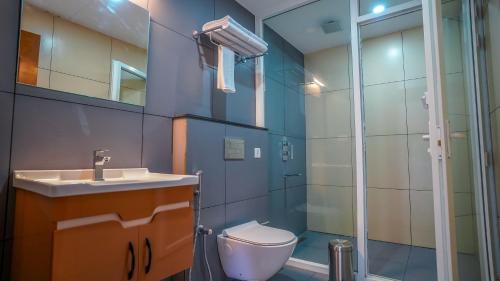 a bathroom with a toilet and a sink and a shower at Winter Note Resorts in Munnar