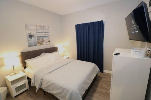 1 dormitorio con cama blanca y cortina azul en Remodeled home in Horizon city, en Horizon City