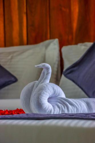 a white swan on top of a bed at Winter Note Resorts in Munnar