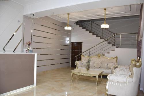 a living room with a couch and a staircase at Dinar in Taraz