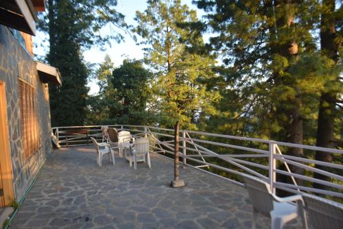 a patio with a table and chairs on it at Sardar House, Dunga Gali in Dunga Gali