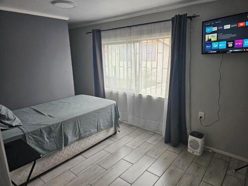 a bedroom with a bed and a television and a window at Departamento Interior 026 2do Piso, Quilicura in Santiago