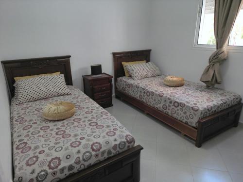 two beds sitting next to each other in a bedroom at Tanger Down Town in Tangier