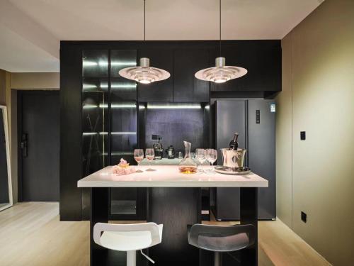 a kitchen with a counter with wine glasses on it at Datong Elite Apartment, Peoples Square, CBD in Shanghai