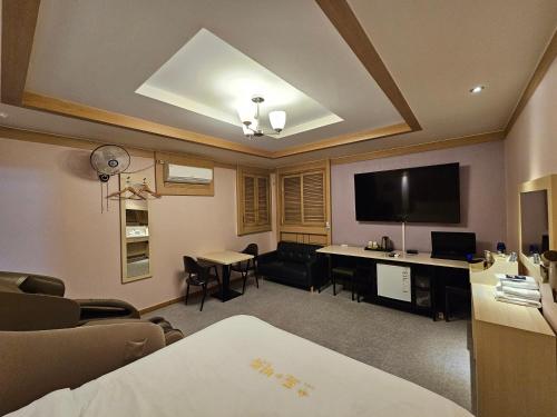 a room with a living room with a table and a tv at Hotel G7 Daejeon in Daejeon