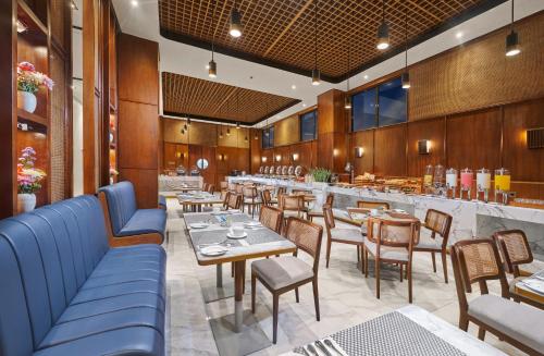 restauracja ze stołami i krzesłami oraz bar w obiekcie The Alana Hotel Malang w mieście Malang