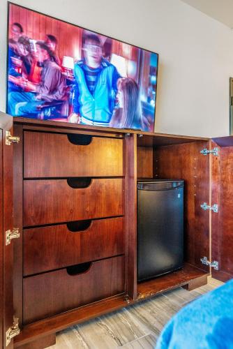 a wooden entertainment center with a flat screen tv at Tempe Corner Apartment Studio King bed in Tempe