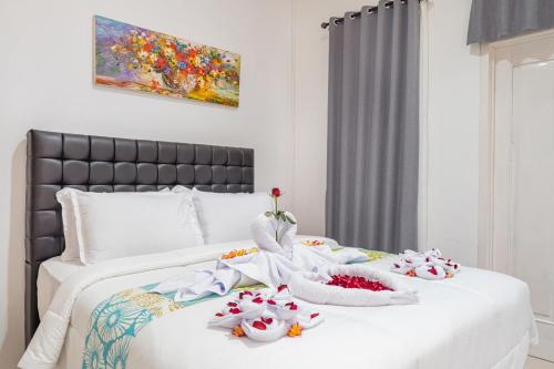 a white bed with towels and flowers on it at 3Bedroom Private Pool Villa Casa De Nuri in Jimbaran