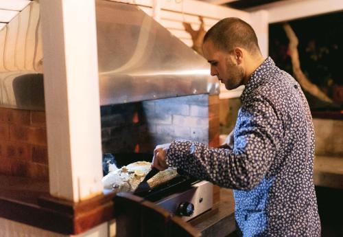 a man is preparing food in an oven at Tree Lodge Mauritius in Belle Mare