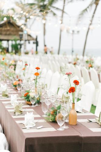 a long table with wine glasses and flowers on it at Palm Garden Beach Resort & Spa in Hoi An