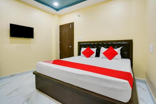 1 dormitorio con 1 cama grande con almohadas rojas en OYO Flagship Heritage Farm Resort, en Itwāri