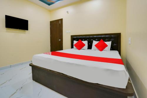 een slaapkamer met een groot bed met rode kussens bij OYO Flagship Heritage Farm Resort in Itwāri