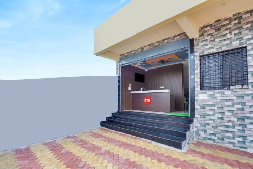 - un bâtiment avec des escaliers et un panneau rouge dans l'établissement OYO Flagship Heritage Farm Resort, à Itwāri