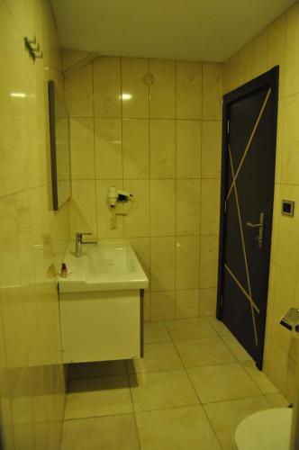 a bathroom with a sink and a shower and a door at Waha Hotel in Bursa