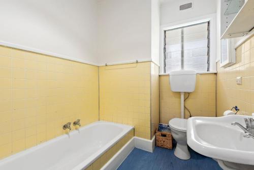 Un baño con bañera, lavabo e inodoro. en Beach Bach, en Point Lonsdale