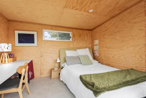 Un dormitorio con una cama y un escritorio en una habitación. en Beach Bach, en Point Lonsdale