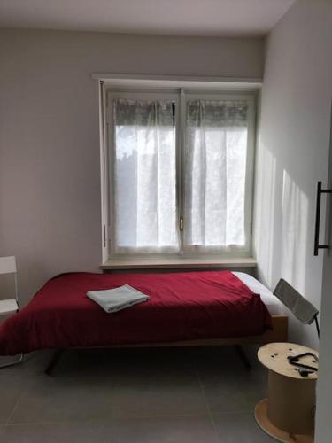 ein Schlafzimmer mit einem roten Bett und einem Fenster in der Unterkunft Villa Mirabella, il bosco in Città. in Turin