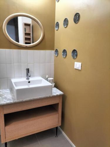 ein Bad mit einem Waschbecken und einem Spiegel in der Unterkunft Villa Mirabella, il bosco in Città. in Turin