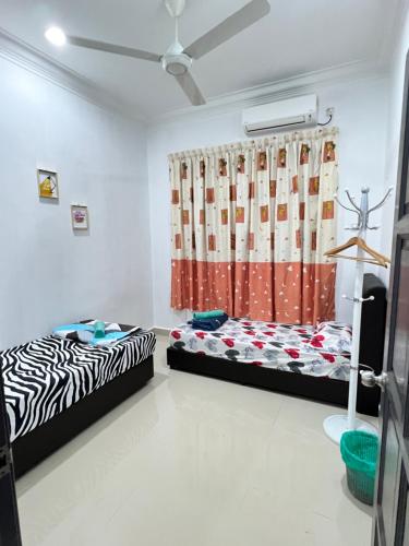2 camas en una habitación con cortina en EMPIRE HOMESTAY PAKA ROOM 3, en Paka