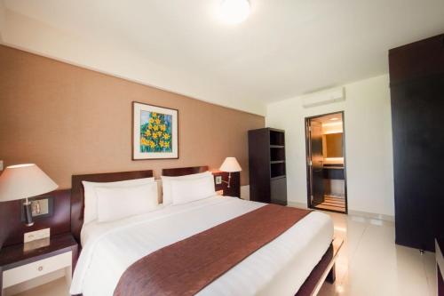 a bedroom with a large bed in a hotel room at Aston Kuta Hotel and Residence in Kuta