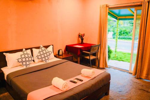 1 dormitorio con cama, mesa y ventana en Villa Bora Bora 8bhk by 29 Bungalow, en Thāl