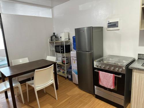 a kitchen with a table and a refrigerator and a table and chairs at Cebu City 2 Bedroom Condo Unit-WIFI-A/C-Hot Shower (U404) in Cebu City