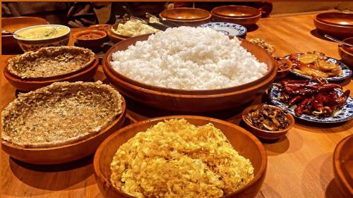 a table topped with bowls of rice and other food at Nobgang B&B "Traditional Heritage HomeStay" in Punākha