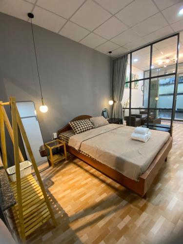 a bedroom with a large bed and a balcony at HOUSE FOR ALL - CANTHO HOMESTAY in Can Tho