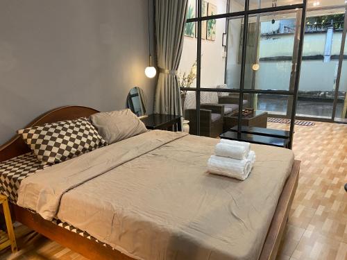 a bedroom with a large bed and a large window at HOUSE FOR ALL - CANTHO HOMESTAY in Can Tho
