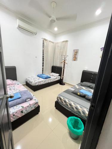 una habitación con 2 camas y un bol azul en ella en EMPIRE HOMESTAY PAKA ROOM 3A, en Paka