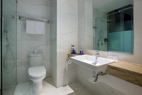 a bathroom with a toilet and a sink and a shower at ASTON Inn Tasikmalaya in Tasikmalaya