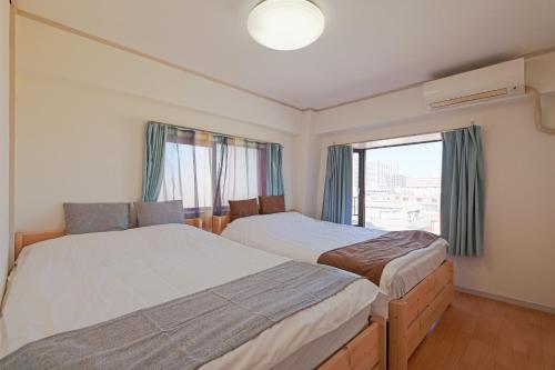 a bedroom with two beds and a window at V.Close to Shinjuku Kabukicho/Korean Town/FrWIFI A in Tokyo