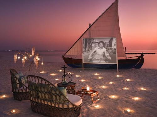 a sail boat sitting on the beach with lights at The Nautilus Maldives in Baa Atoll