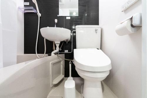 een badkamer met een toilet, een wastafel en een bad bij JASPER Waseda in Tokyo