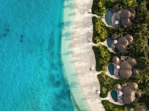an aerial view of a beach with umbrellas and the ocean at The Nautilus Maldives in Baa Atoll