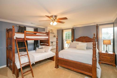 een slaapkamer met 2 stapelbedden en een plafondventilator bij NEW Outdoor Oasis Pool, Hot Tub, Firepl, 6 bedr in Franklin
