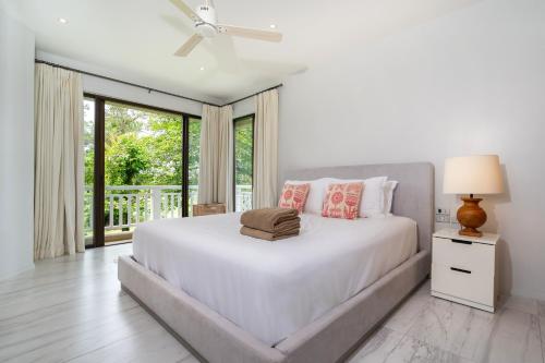 a white bedroom with a large bed and a window at Spacious 2BR Apartment Allamanda II in Laguna, 10 min from BangTao Beach in Bang Tao Beach