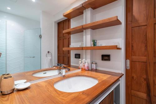 uma casa de banho com um lavatório e uma cabina de duche em vidro. em Spacious 2BR Apartment Allamanda II in Laguna, 10 min from BangTao Beach em Praia de Bang Tao