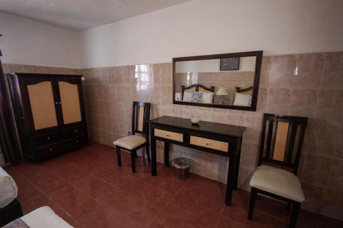 a room with a vanity and a mirror and a bed at Hotel del Sol in San Miguel de Allende