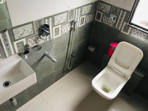 La petite salle de bains est pourvue d'un lavabo et de toilettes. dans l'établissement Hotel KF Residency, à Mumbai